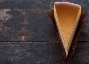 Ahşap masa üstüne peynir pasta bir dilim