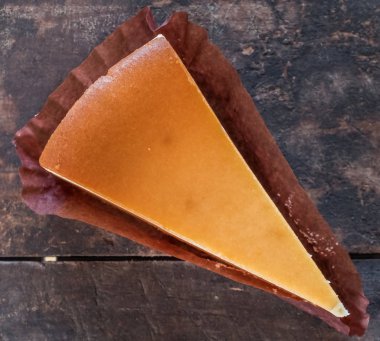 Ahşap masa üstüne peynir pasta bir dilim