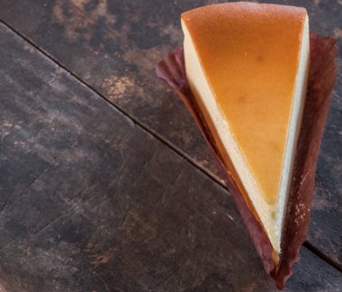 Ahşap masa üstüne peynir pasta bir dilim