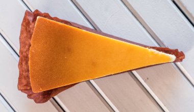 Ahşap masa üstüne peynir pasta bir dilim