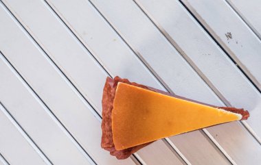 Ahşap masa üstüne peynir pasta bir dilim