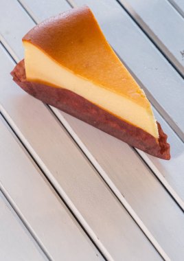 Ahşap masa üstüne peynir pasta bir dilim