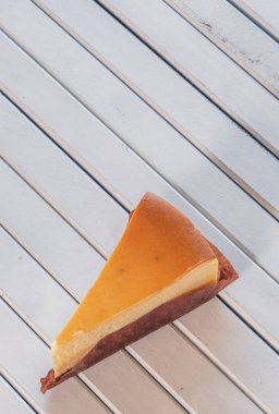 Ahşap masa üstüne peynir pasta bir dilim