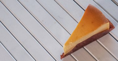 Ahşap masa üstüne peynir pasta bir dilim