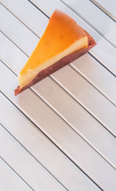 Ahşap masa üstüne peynir pasta bir dilim