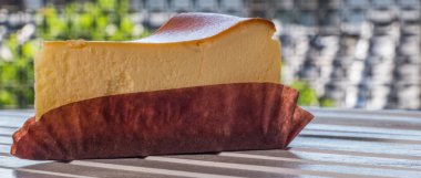 Ahşap masa üstüne peynir pasta bir dilim