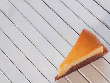 Ahşap masa üstüne peynir pasta bir dilim