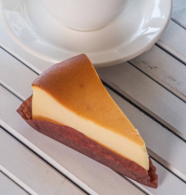 Ahşap masa üstüne peynir pasta bir dilim