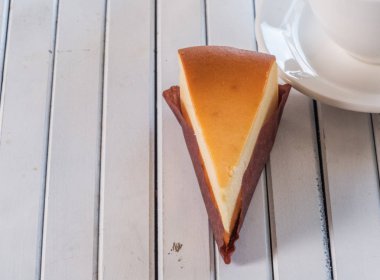 Ahşap masa üstüne peynir pasta bir dilim