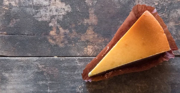 Ahşap masa üstüne peynir pasta bir dilim