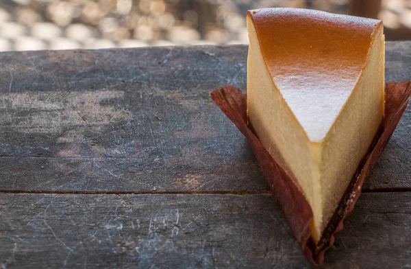 Ahşap masa üstüne peynir pasta bir dilim