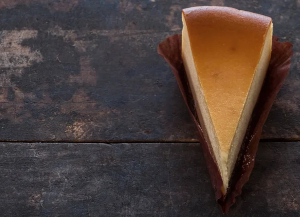 Ahşap masa üstüne peynir pasta bir dilim