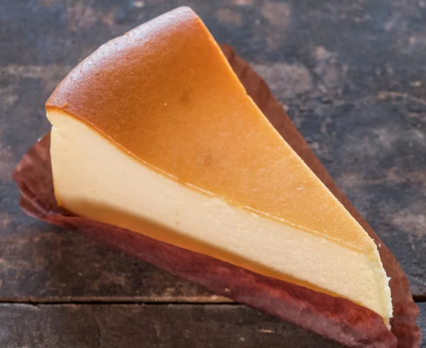 Ahşap masa üstüne peynir pasta bir dilim