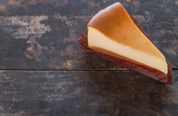 Ahşap masa üstüne peynir pasta bir dilim