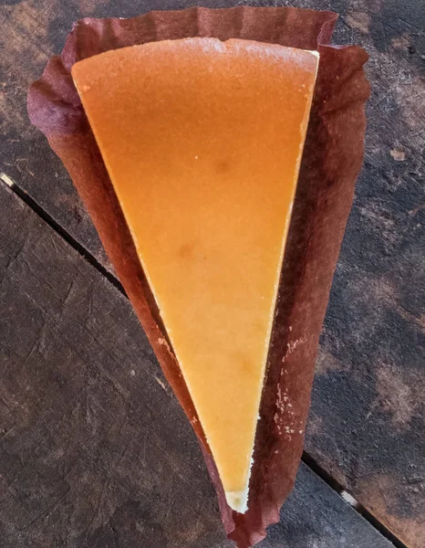 Ahşap masa üstüne peynir pasta bir dilim