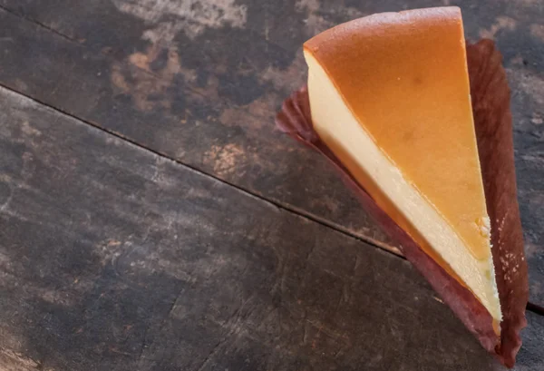 Ahşap masa üstüne peynir pasta bir dilim