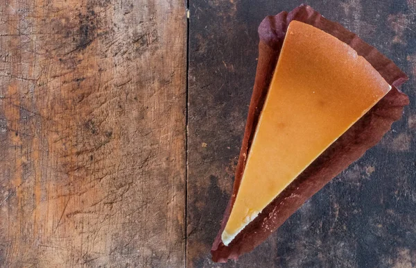 Ahşap masa üstüne peynir pasta bir dilim