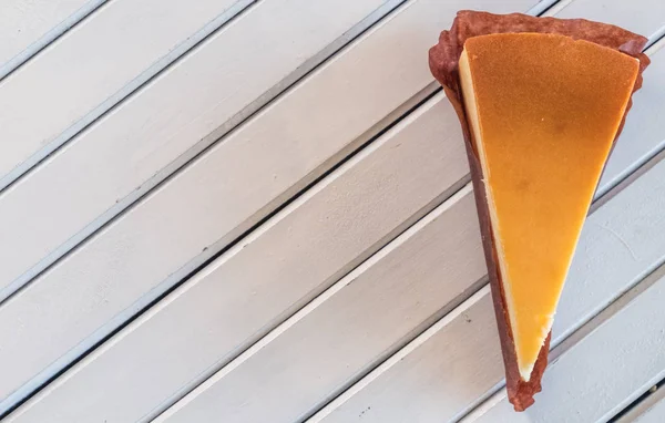 Ahşap masa üstüne peynir pasta bir dilim