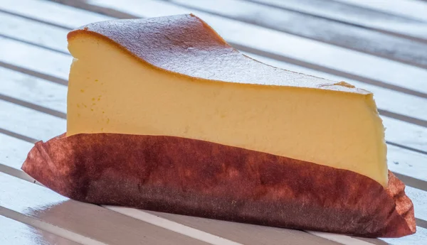 Ahşap masa üstüne peynir pasta bir dilim