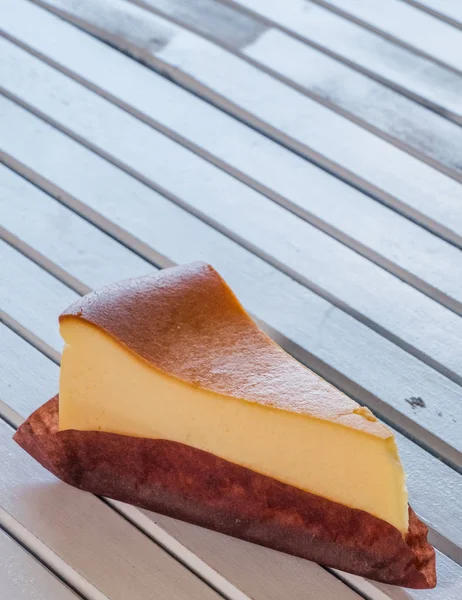 Ahşap masa üstüne peynir pasta bir dilim