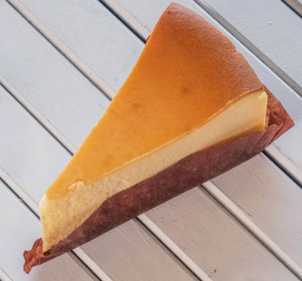 Ahşap masa üstüne peynir pasta bir dilim