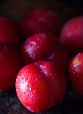 Koyu ahşap arka plan üzerinde kırmızı erik