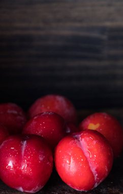 Koyu ahşap arka plan üzerinde kırmızı erik