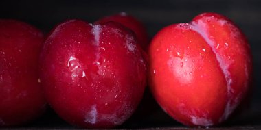 Koyu ahşap arka plan üzerinde kırmızı erik