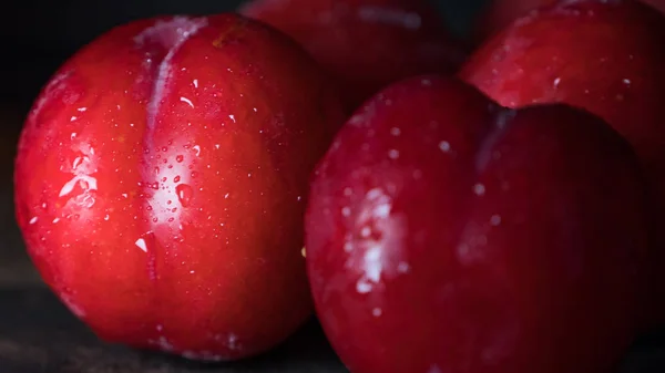 Plum Merah Atas Latar Belakang Kayu Gelap — Stok Foto