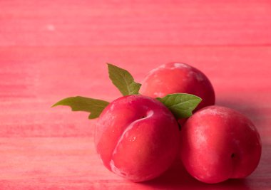 Koyu ahşap arka plan üzerinde kırmızı erik