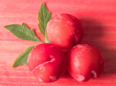 Koyu ahşap arka plan üzerinde kırmızı erik