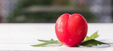 Koyu ahşap arka plan üzerinde kırmızı erik