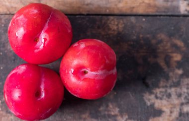 Koyu ahşap arka plan üzerinde kırmızı erik