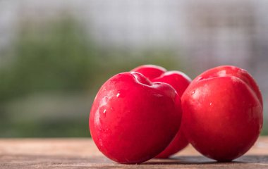 Koyu ahşap arka plan üzerinde kırmızı erik