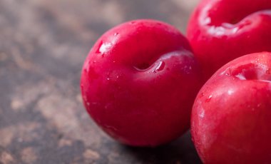 Koyu ahşap arka plan üzerinde kırmızı erik