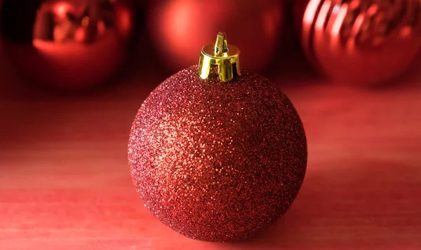 Kırmızı ahşap zemin üzerinde Noel topları