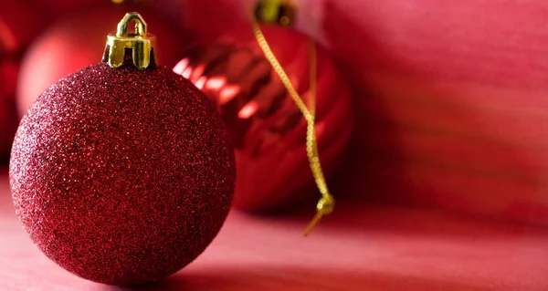 Kırmızı ahşap zemin üzerinde Noel topları