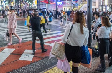 Tokyo, Japonya - 23 Haziran 2018. Geceleri Shibuya içinde karşıya insanlar