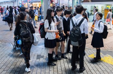 Tokyo, Japonya - 23 Haziran 2018. Japon lise öğrencisi Shibuya sokakta geceleri dışarı asılı.