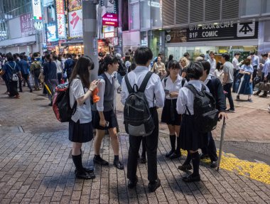 Tokyo, Japonya - 23 Haziran 2018. Japon lise öğrencisi Shibuya sokakta geceleri dışarı asılı.