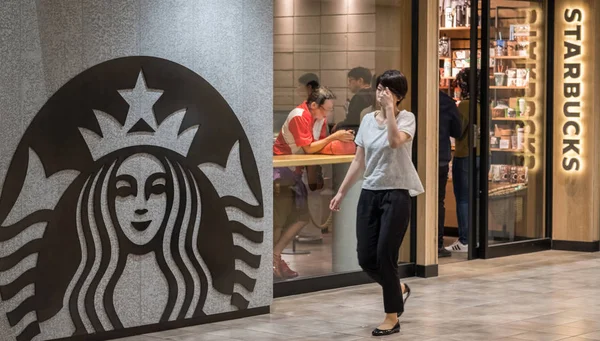 Tokyo, Japonya - 23 Haziran 2018. İnsanların önünde ofstarbucks kahve yürüyüş çıkış Shibuya içinde ev.