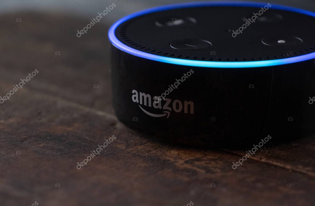 TOKYO, JAPAN - JUNE 28TH, 2018. Amazon's Echo Dot, Alexa virtual assistant on wooden board.