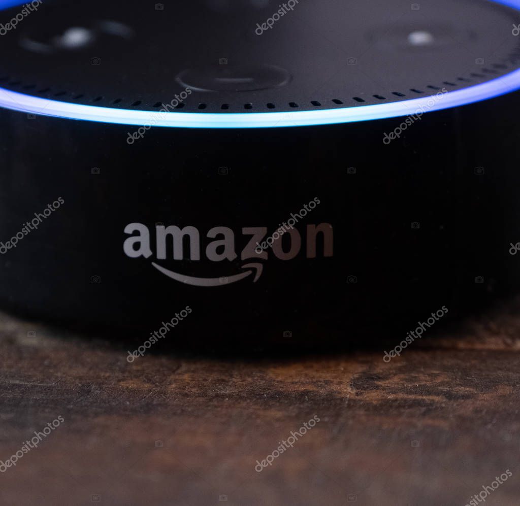TOKYO, JAPAN - JUNE 28TH, 2018. Amazon's Echo Dot, Alexa virtual assistant on wooden board.
