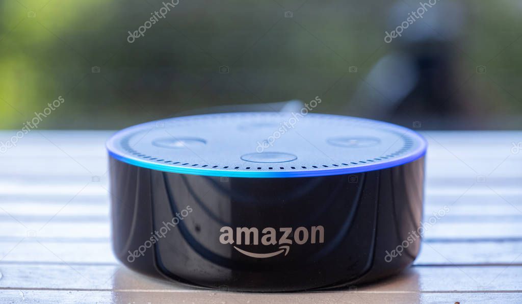 TOKYO, JAPAN - JUNE 28TH, 2018. Amazon's Echo Dot, Alexa virtual assistant on wooden board.