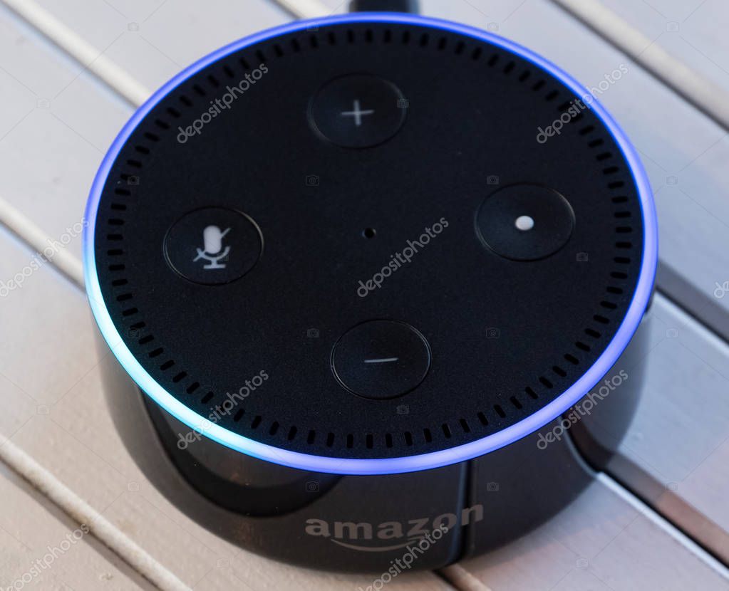 TOKYO, JAPAN - JUNE 28TH, 2018. Amazon's Echo Dot, Alexa virtual assistant on wooden board.