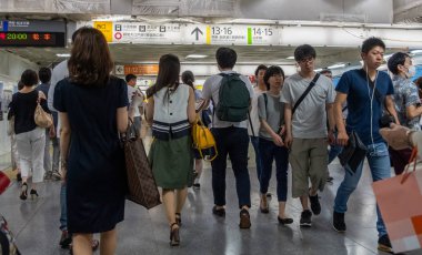 Tokyo, Japonya - 30 Haziran 2018. Japonya demiryolu Shinjuku İstasyonu platformları arasında yürüyüş commuters.
