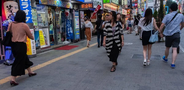 Tokyo, Japonya - 30 Haziran 2018. Turistler ve yerliler için Kabukicho, Shinjuku sokakta yürürken, kalabalık.