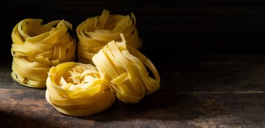 Ahşap tahta üzerinde kurutulmuş tagliatelle makarna