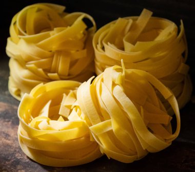 Ahşap tahta üzerinde kurutulmuş tagliatelle makarna