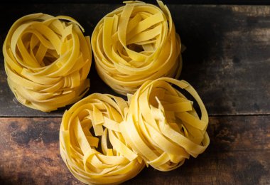 Ahşap tahta üzerinde kurutulmuş tagliatelle makarna